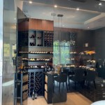 Transitional home wine cellars combine elements of both modern and traditional design, such as glass walls and wooden racking.